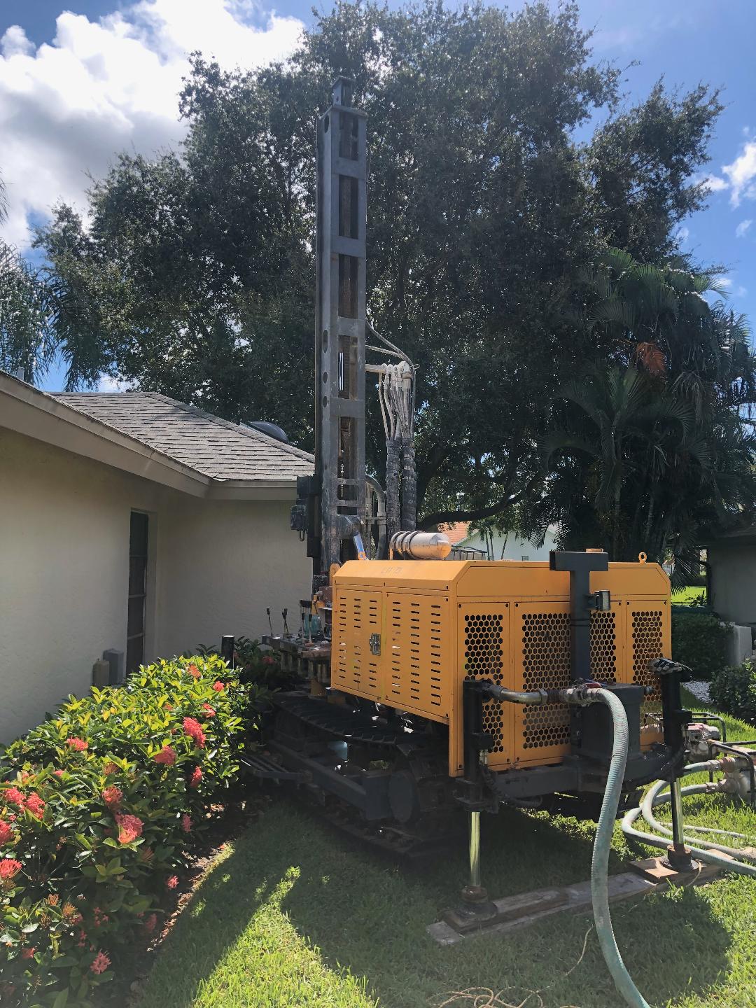 Well drilling rig beside a residential home